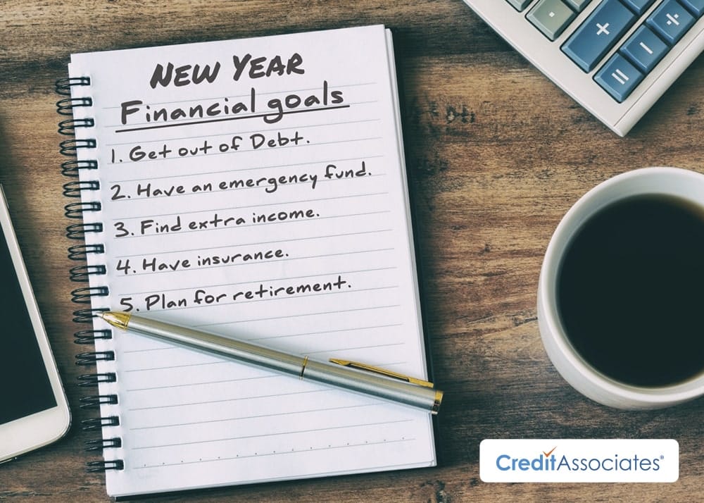 New Year's financial goals checklist written in notebook on desk.